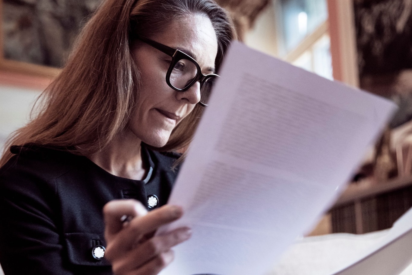 Žena kontrolujúca dokumenty pri nahlásení poistnej udalosti a vypĺňaní formulárov poisťovne.