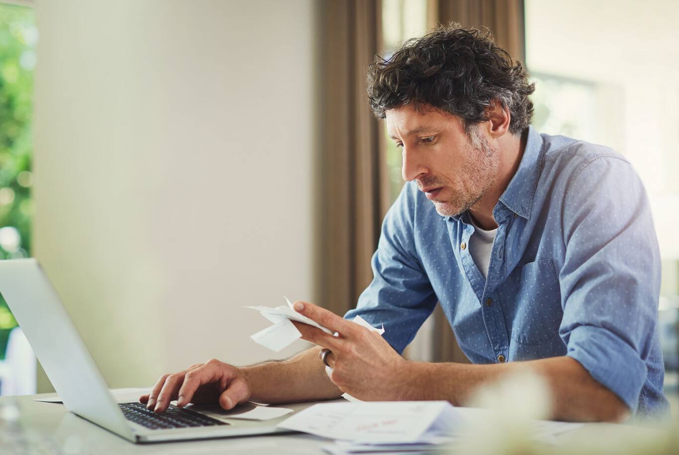 Dospelý muž, ktorý počíta mesačný rodinný rozpočet