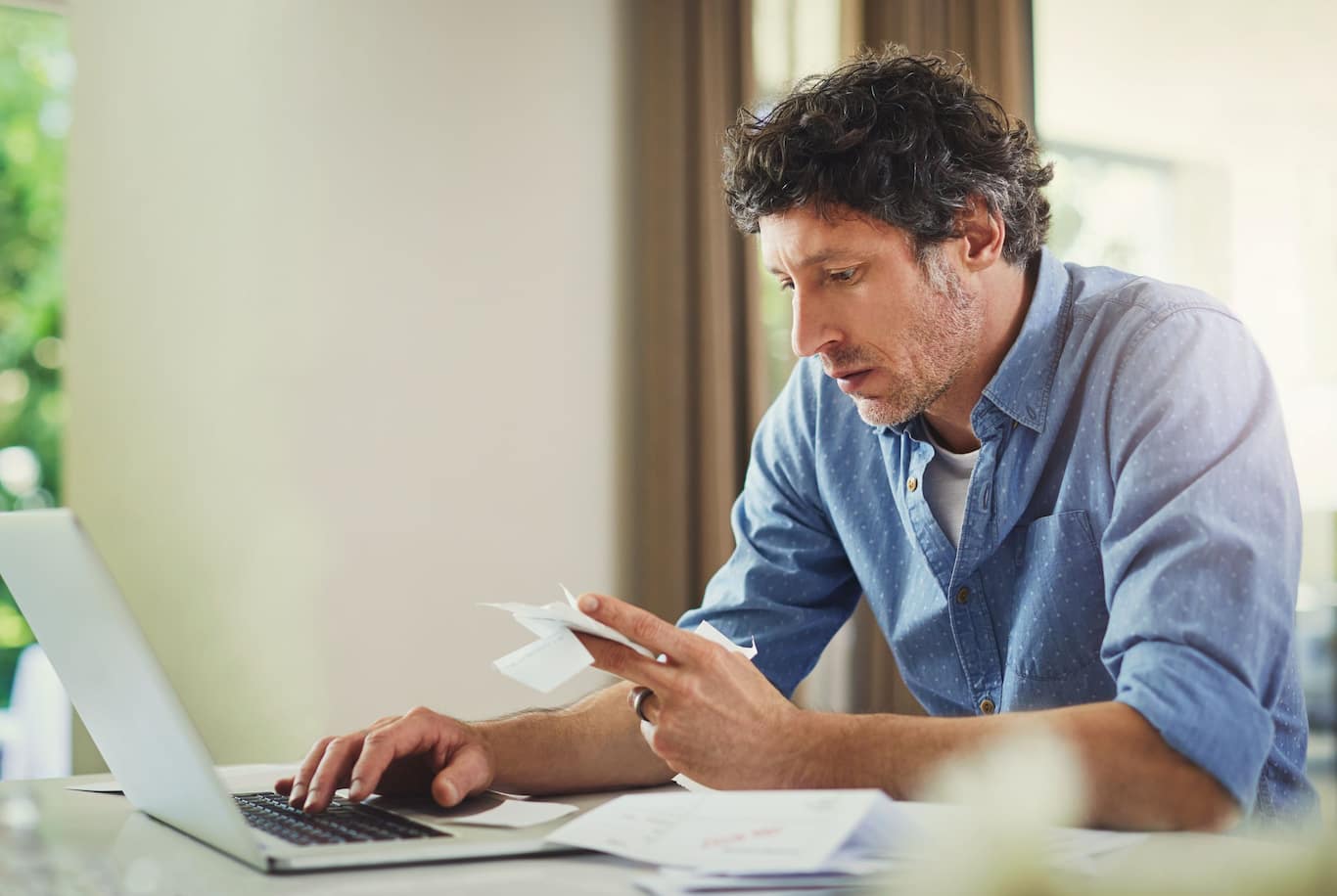 Dospelý muž, ktorý počíta mesačný rodinný rozpočet