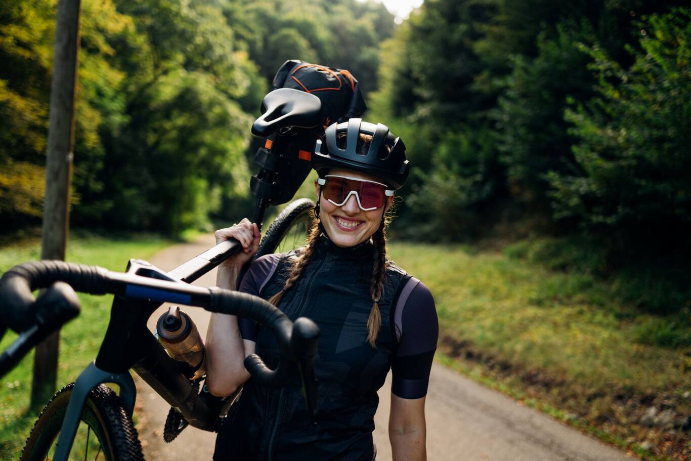 Žena s horským bicyklom v cyklistickej výbave počas športovej aktivity v prírode. 