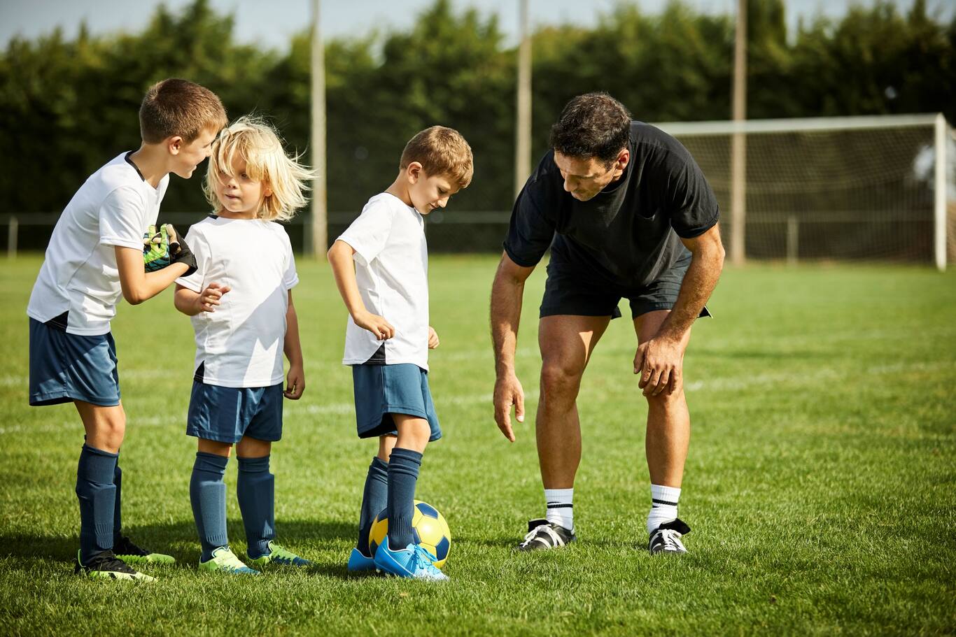 Otec, ktorý hrá futbal s jeho deťmi na vonkajšom ihrisku