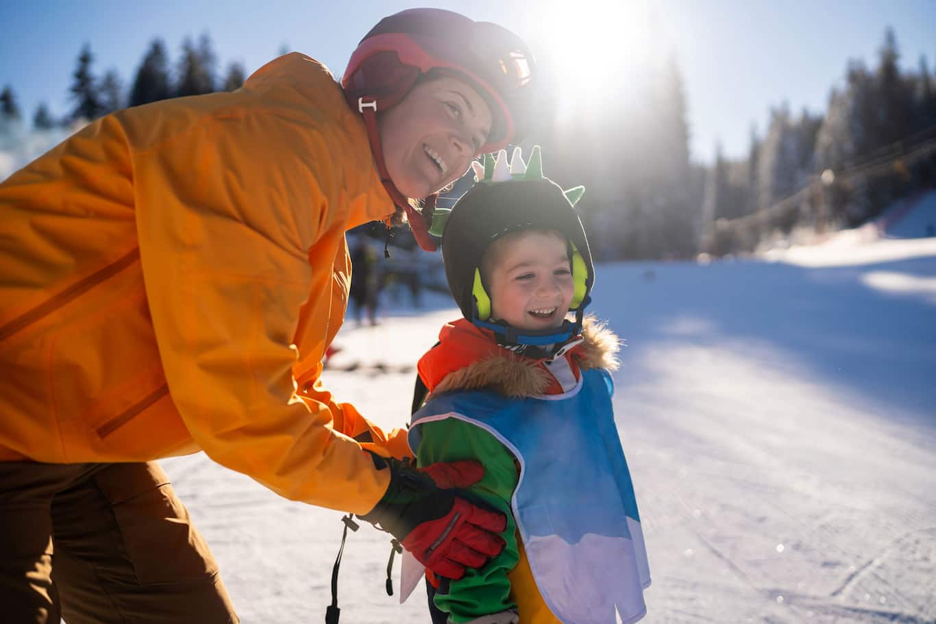 Matka s dieťaťom na lyžiarskom svahu, usmiati a šťastní